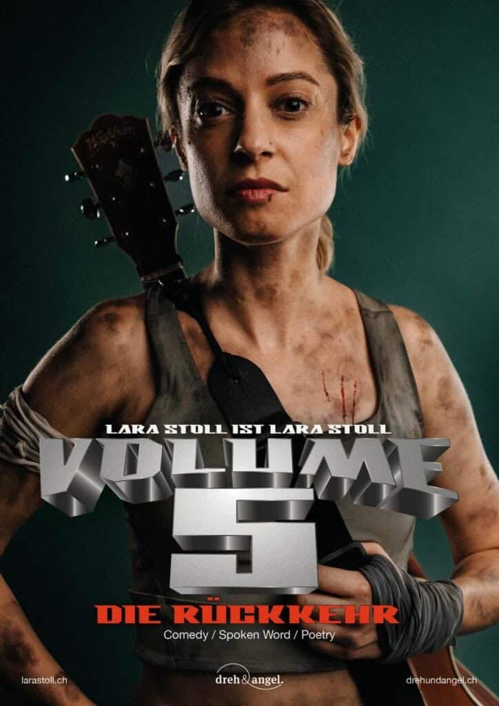 Lara Stoll mit Gitarre, düsteres Bühnenbild, Musik- und Comedy-Performance.